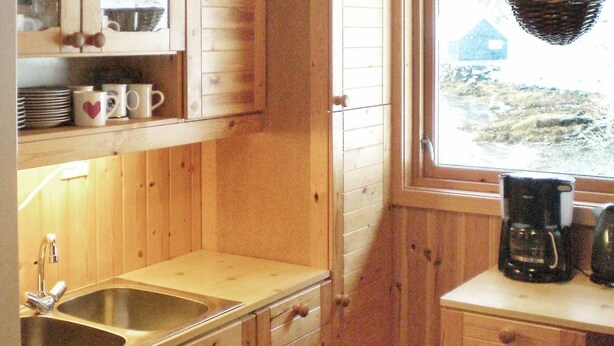 A wooden cabin kitchen with a sink, cabinets, and a coffee maker. - 8 Person Holiday Home in Nordfjordeid-by Traum (Stad)