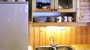 A kitchen with wooden cabinets, a double sink, and a refrigerator. - 8 Person Holiday Home in Nordfjordeid-by Traum (Stad)