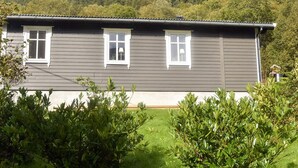 A two-story house with a dark siding exterior, white trim around windows, and a flat roof. - 4 Star Holiday Home in Aram (Vanylven)