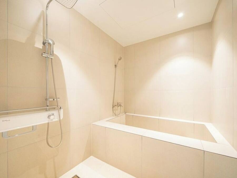 Un baño moderno con bañera, ducha y barra de apoyo.