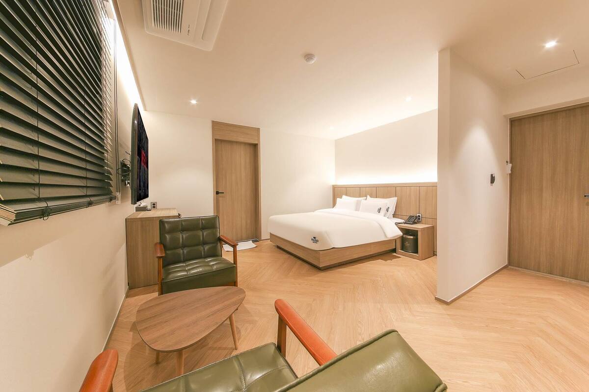 Una habitación de hotel con cama, escritorio, silla y mesa.