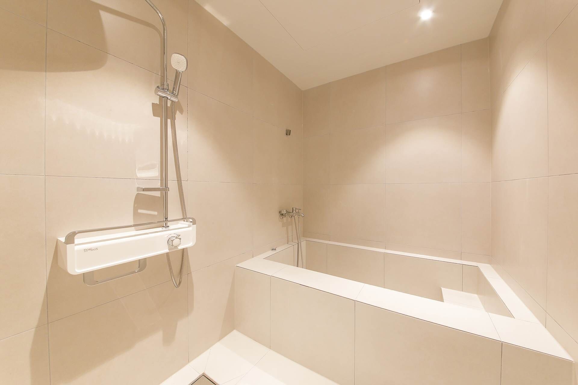 A modern bathroom with a bathtub, a shower, and a toilet.