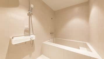 A modern bathroom with a bathtub, a shower, and a toilet.