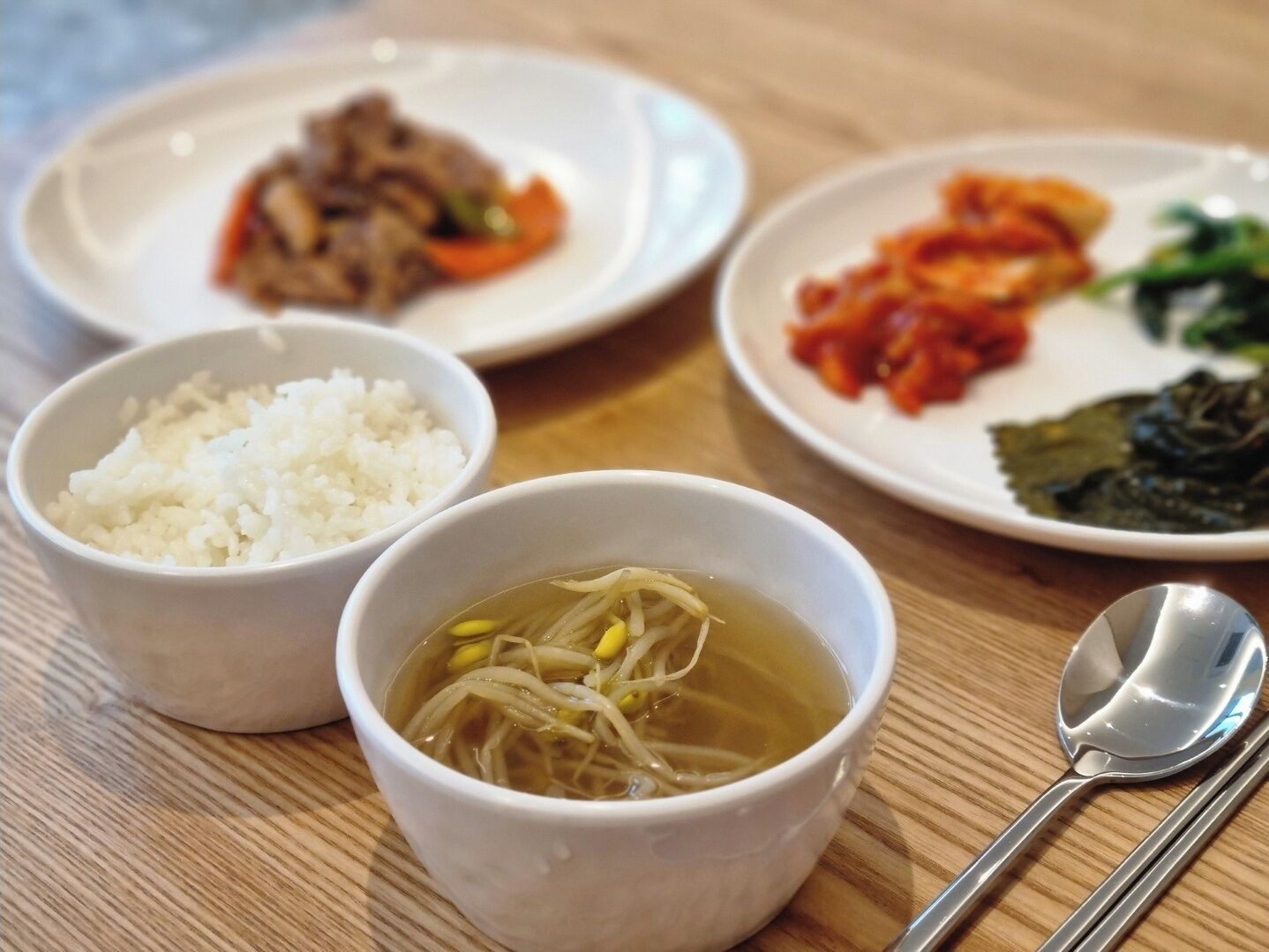 Una mesa con diversos platos, incluyendo arroz, sopa y fuentes con diferentes comidas.