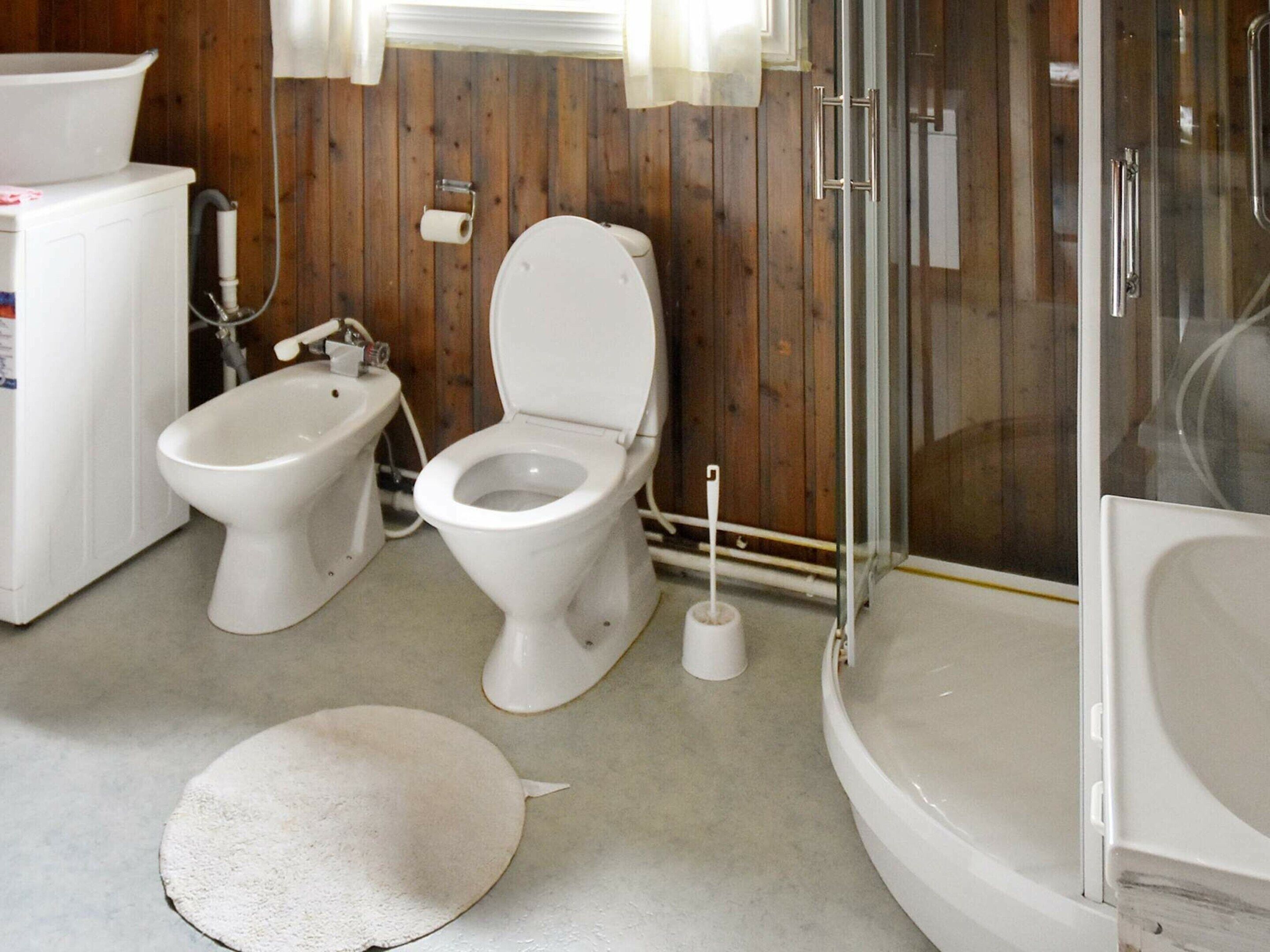 A bathroom with a toilet, bidet, and shower.