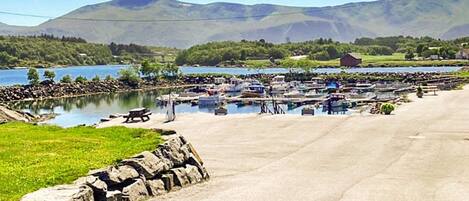 A marina with boats docked, a picnic table, and a stone wall.