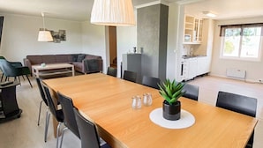 Un espace repas moderne avec une table en bois, des chaises noires et une plante en pot.