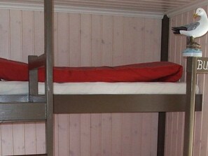 A bunk bed with a red mattress and a bird decoration on the headboard. - 5 Star Holiday Home in Kalvag (Bremanger)