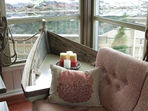 A cozy corner with a cushioned bench, a decorative pillow, and candles on a windowsill. - 5 Star Holiday Home in Kalvag (Bremanger)