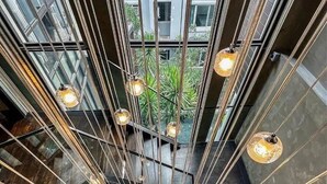 A modern interior with a central staircase, metal railings, and hanging pendant lights. - The Oasis Tranquil Escape (Bangkok)