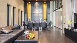 A modern living room with a sofa, dining table, and chandelier. - The Oasis Tranquil Escape (Bangkok)