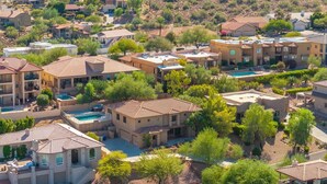 Zona residenziale con case dotate di tetti in tegole rosse, immersa nel verde e con uno sfondo collinare.