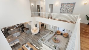Un'ampia zona giorno con soffitto alto, una sala da pranzo e una cucina.