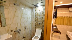 Une salle de bain comprenant des toilettes, un lavabo et un espace douche.