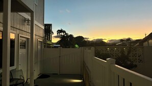 Un balcone con vista sul tramonto, una porta e una sedia.