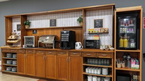 A buffet setup with a coffee station, food display, and beverage fridge. - Alda Malvasia (Haro)