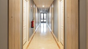 A long, narrow hallway with wooden paneling on the walls and a tiled floor. - Alda Malvasia (Haro)