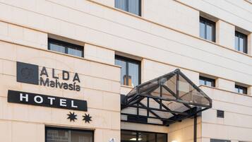 A hotel entrance with a sign reading "ALDA Malvásia HOTEL".