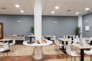 A modern dining area with round tables, white chairs, and a central column. - Alda Malvasia (Haro)