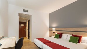 A hotel room with a bed, bedside table, chair, and a desk. - Alda Malvasia (Haro)