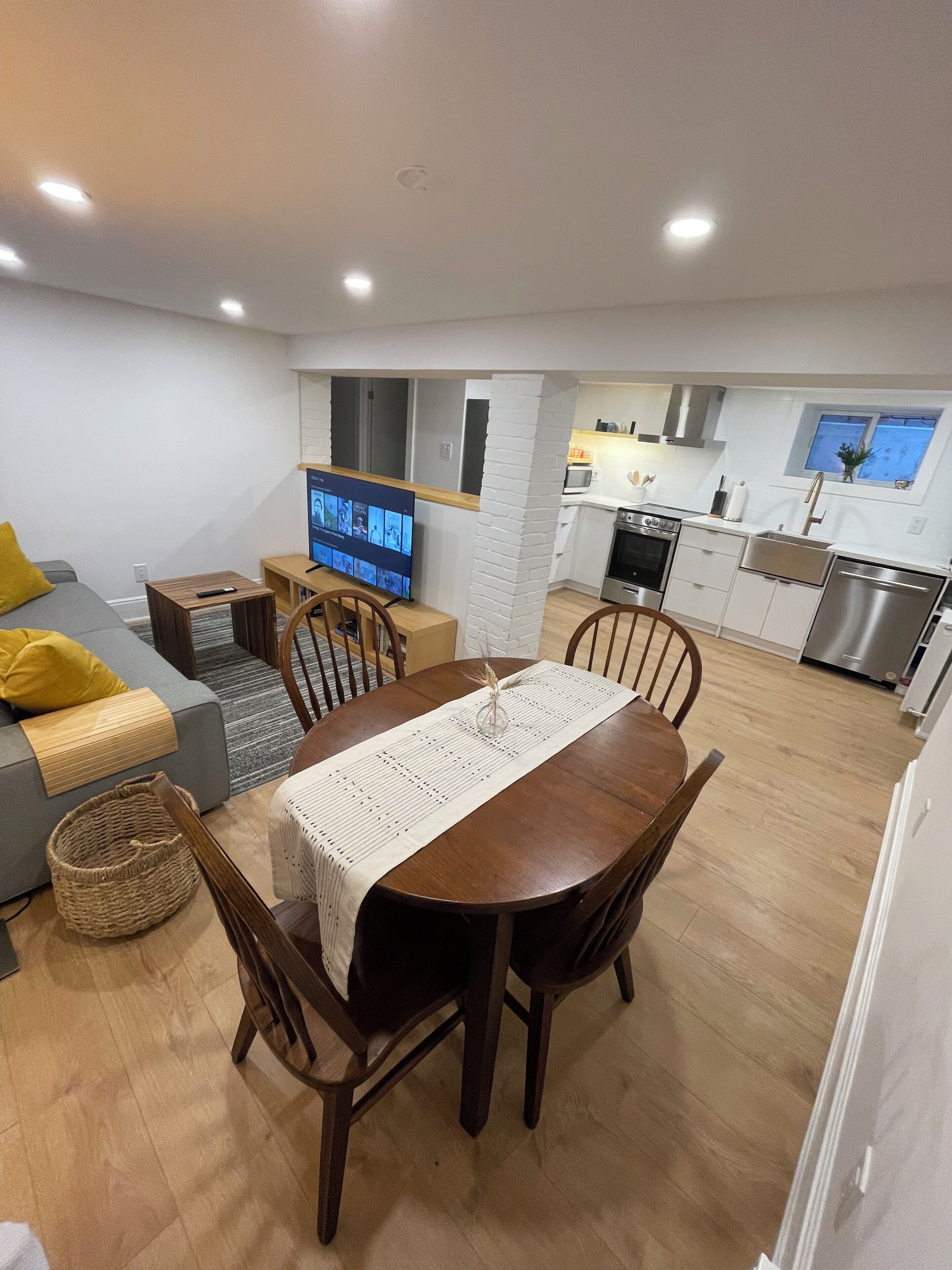 A modern apartment with a dining area, kitchen, and living space.