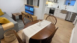 A modern apartment with a dining area, kitchen, and living space.