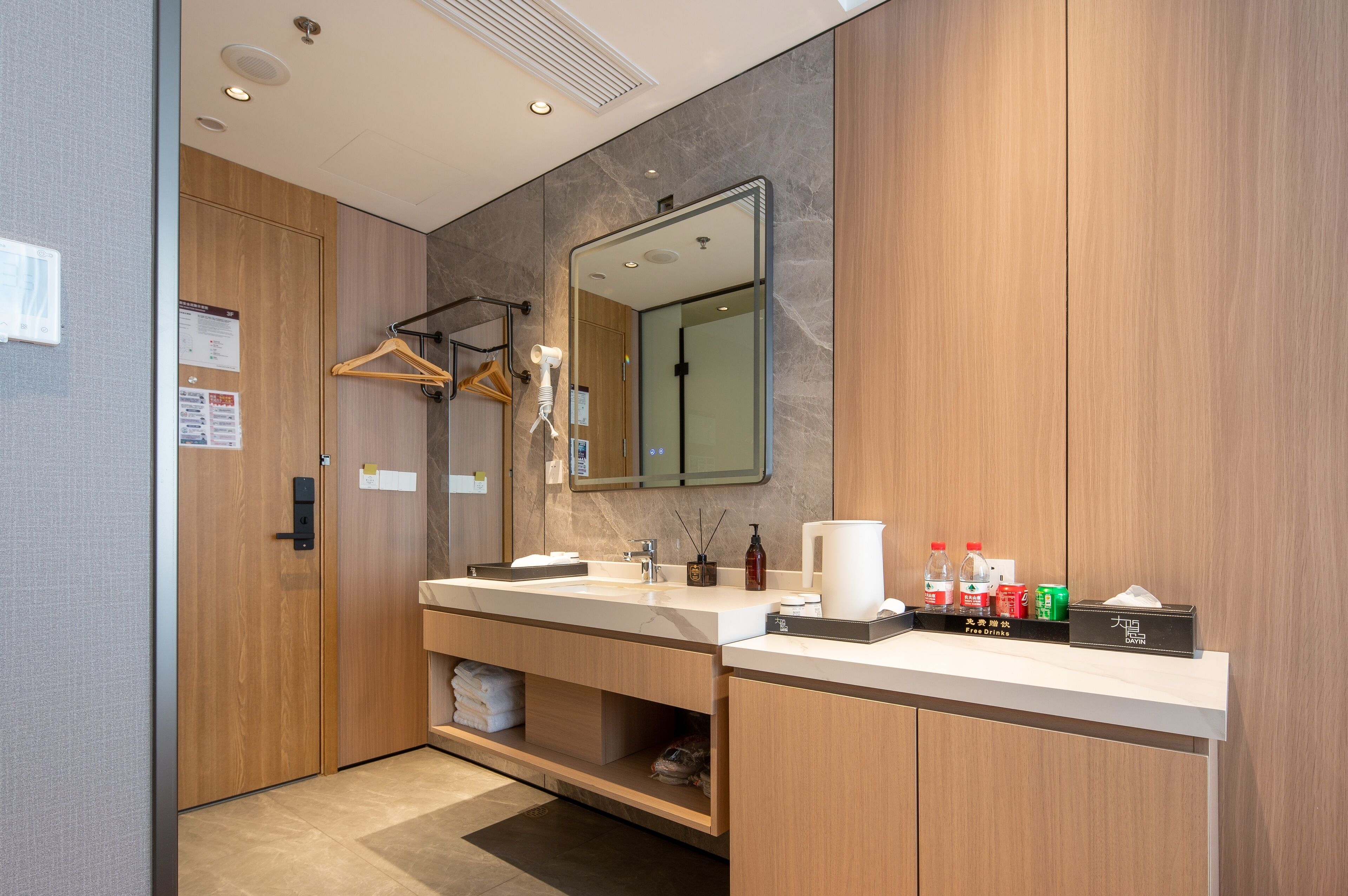 Une salle de bain moderne avec un meuble-lavabo en bois, un grand miroir et un porte-serviettes.
