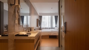 A modern hotel room with a large bed, a bathroom with a mirror, and a wooden door. - Dayin Serene Garden Hotel - Shanghai Jing'an Joy City Suzhou Creek (Shanghai)