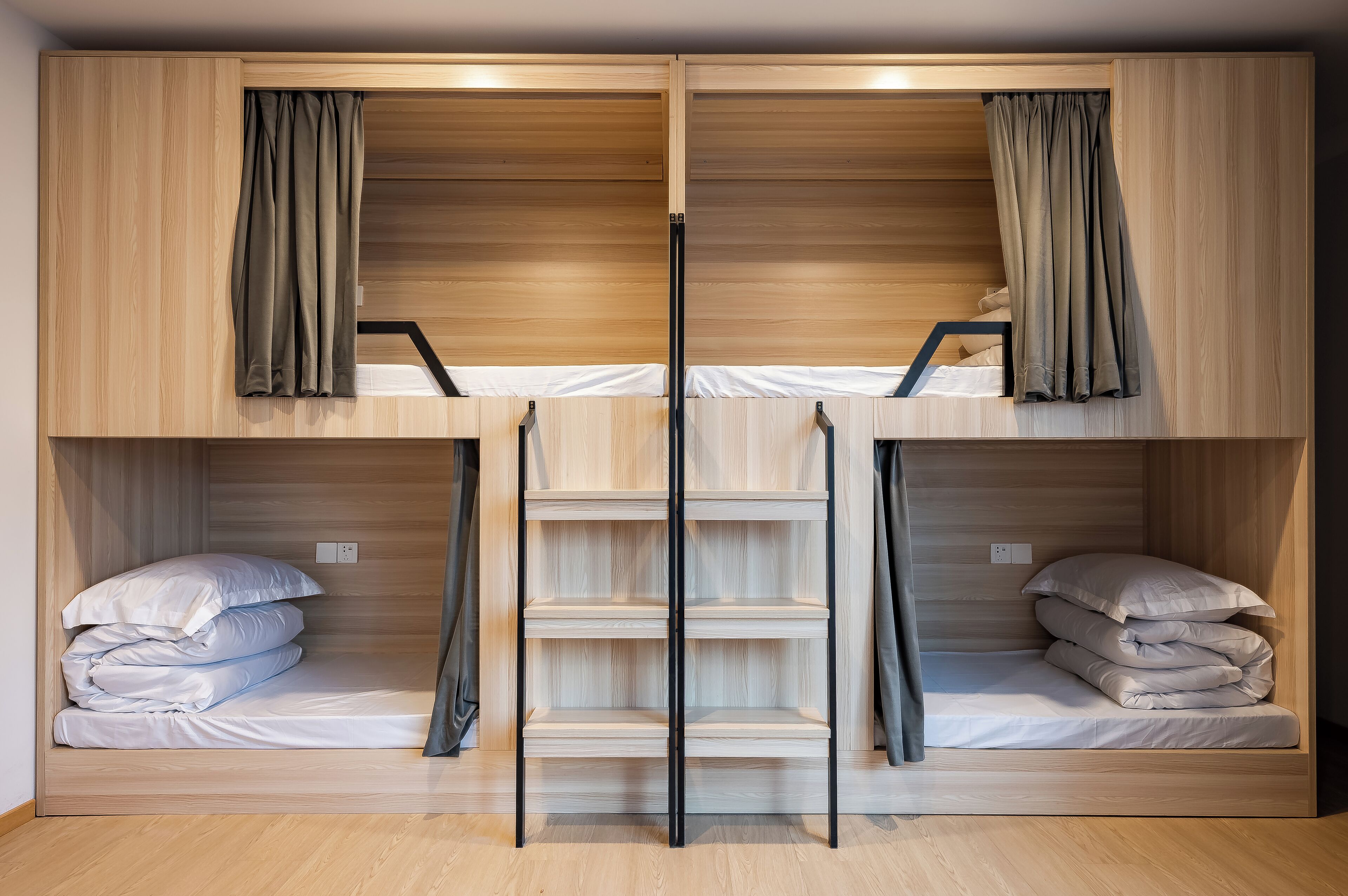 A bunk bed room with wooden walls and curtains.