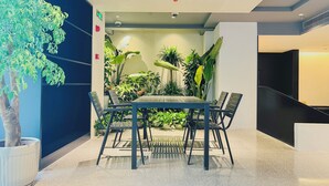 A modern indoor space with a table and chairs, surrounded by lush green plants and a potted tree. - Dayin Serene Garden Hotel - Shanghai Jing'an Joy City Suzhou Creek (Shanghai)