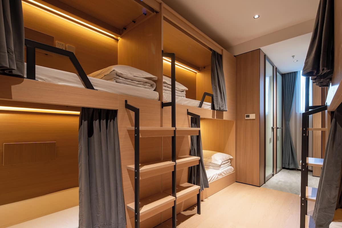 A modern, multi-level bunk bed room with built-in shelves and a cozy, warm ambiance.