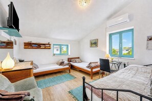 A bedroom with two single beds, a desk, a chair, a TV, and a bookshelf. - Villa Salamander Suite - Garden & EV charger, Štanjel, Slovenia (Štanjel)