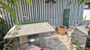 A stone table with a green bench, potted plants, and a wooden deck. - Villa Salamander Suite - Garden & EV charger, Štanjel, Slovenia (Štanjel)