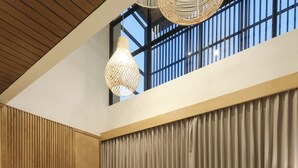 Een moderne woonkamer met een grote flatscreen-tv, een bank, een salontafel en een houten accentmuur.