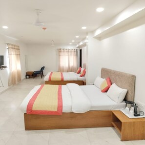 Une chambre d’hôtel avec deux lits, un bureau et une chaise.