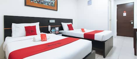 A hotel room with two beds, each with white bedding and red accents, a painting above the beds, a clock on the wall, and a door with a sign.