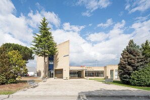 Un bâtiment qui abrite un café appelé « cafétaria » et devant lequel se trouve un grand arbre.