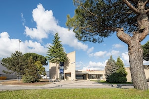 A building with a cafe and restaurant sign, surrounded by trees and a clear sky.