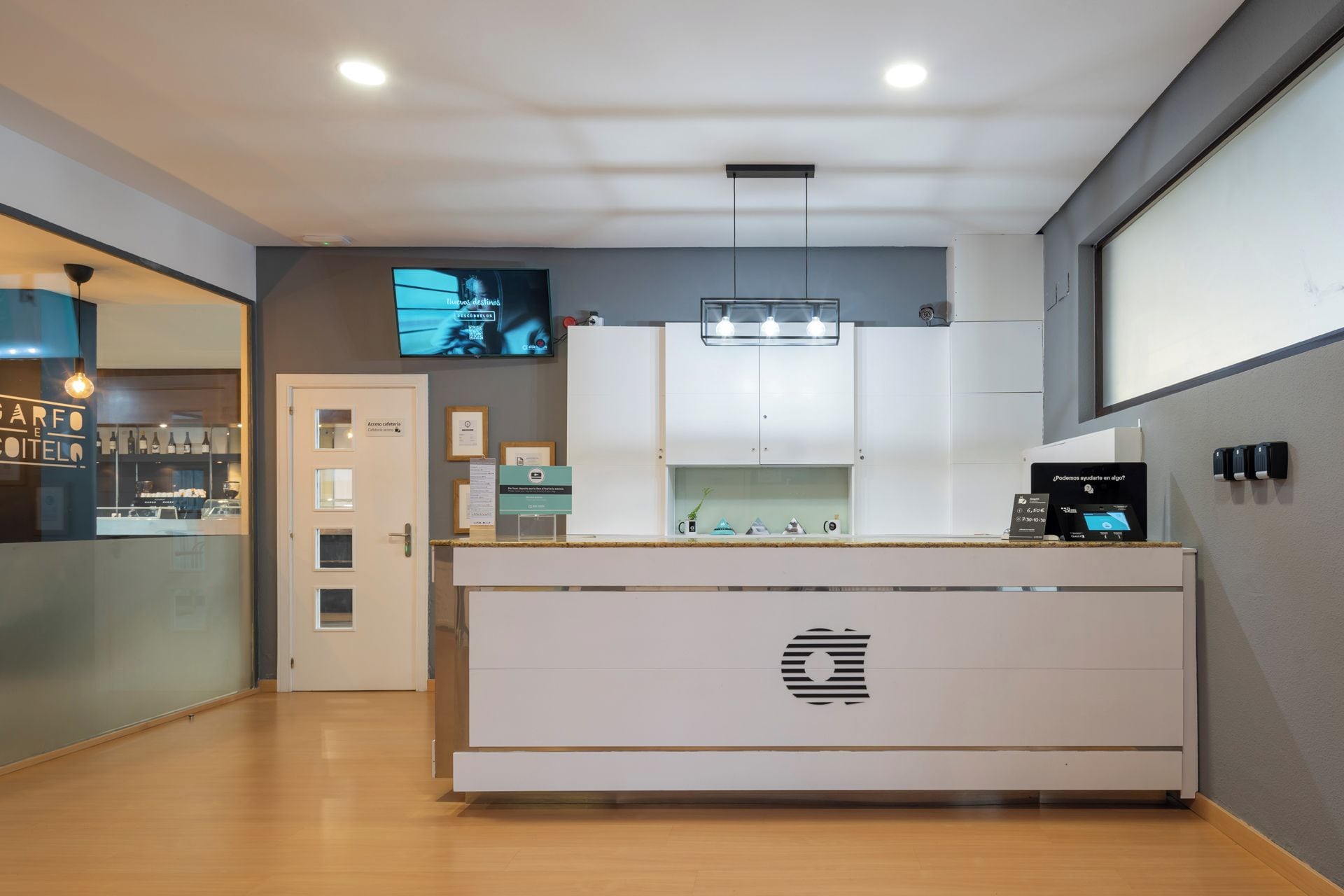 A modern kitchen with a central island, a built-in oven, and a television mounted on the wall.