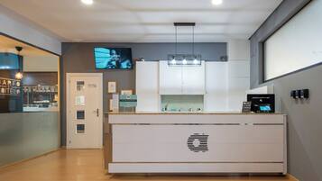 A modern kitchen with a central island, a built-in oven, and a television mounted on the wall.