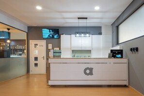 A modern kitchen with a central island, a built-in oven, and a television mounted on the wall. - Alda Puerto Seco (Burgos)