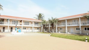 A hotel courtyard with a central fountain, multiple balconies, and palm trees.