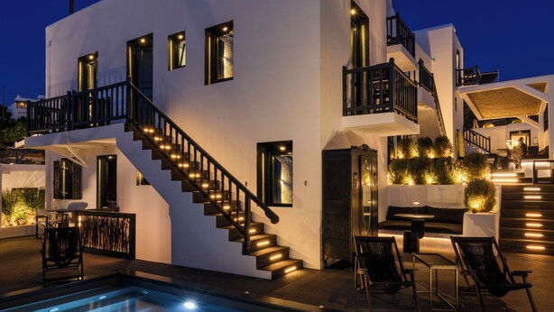 Un bâtiment moderne doté d’une piscine, d’un espace extérieur aménagé et d’un escalier menant à un balcon.
