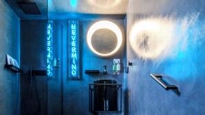 Een moderne badkamer met een douchecabine van glas, een wastafel en een spiegel.