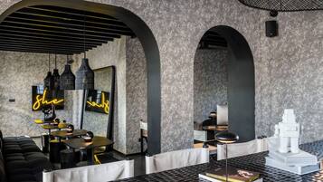 A modern interior with arched ceilings, black and white furnishings, and a neon sign.