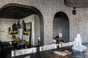 Un intérieur moderne avec des plafonds en arc de cercle, des meubles aux couleurs noir et blanc et un panneau lumineux au néon.