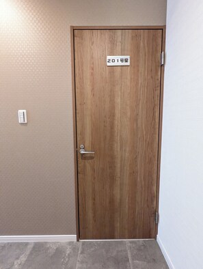 Een houten deur met een bord waarop staat '201号室' (Kamer 201).