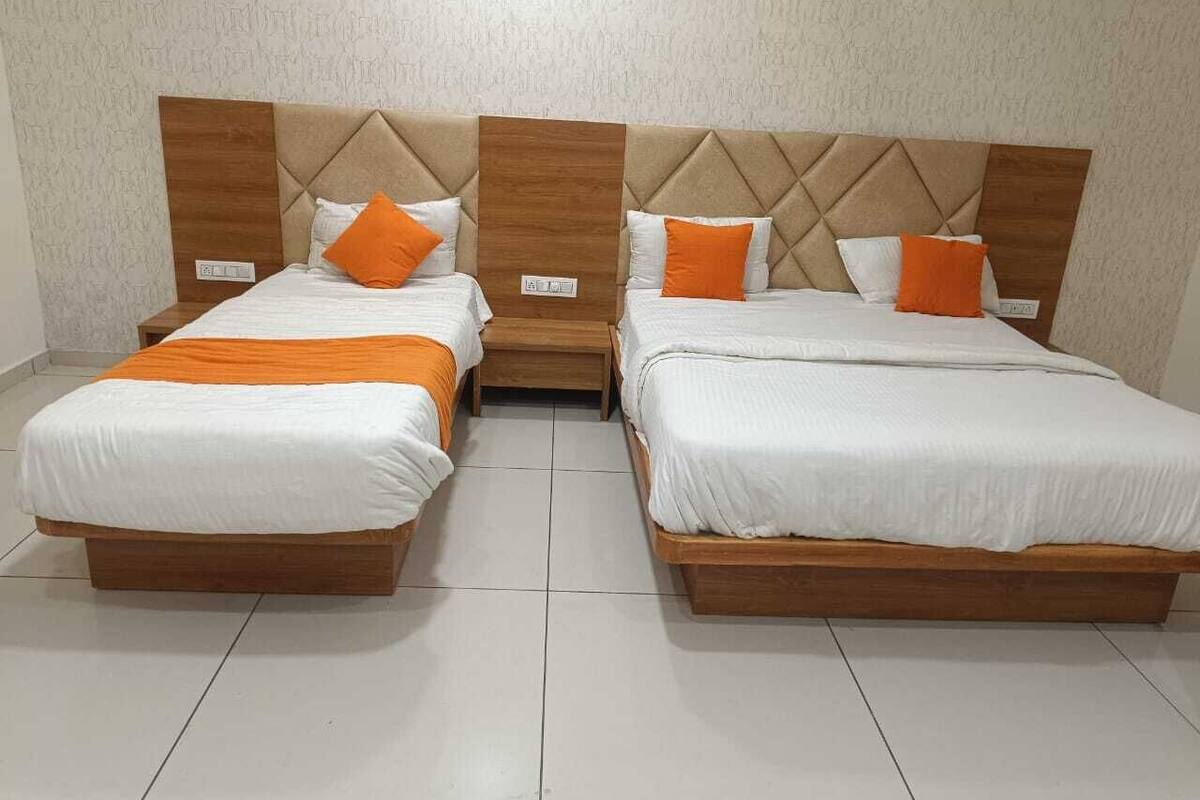 A hotel room with two beds, each with wooden headboards and white bedding.