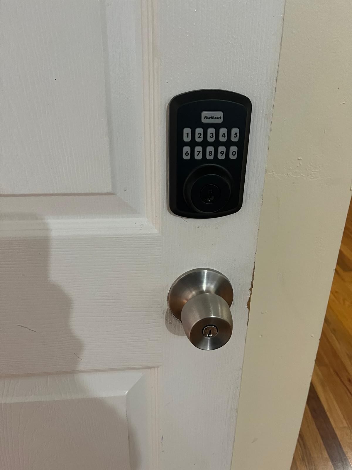 A door with a keypad lock and a keyhole.