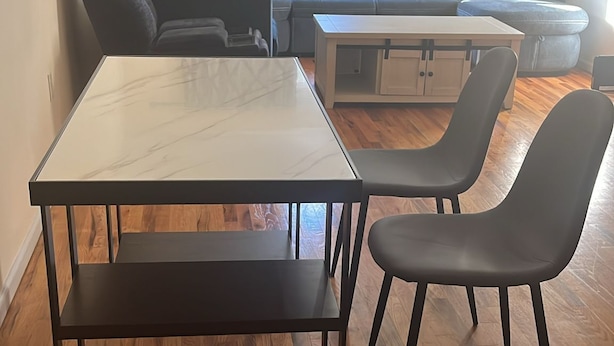A living room with a sofa set, a coffee table, and a dining table with chairs. - NWK 457  ROOM 112-B (Newark)